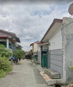 una strada con un edificio con porta verde di SPOT ON 93851 Fermansio Homestay 1 a Medan