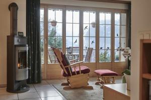 a living room with a chair and a fireplace at Chalet Panorama 1 in Wengen