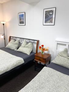 a bedroom with two beds and a table with flowers on it at Ubytování Šantovka in Olomouc