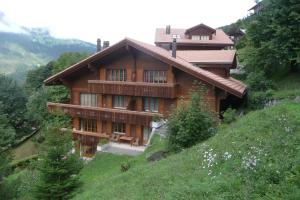a large wooden house on a hill at Chalet Panorama 1 in Wengen