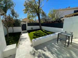einen Garten mit einer Bank und einem Tisch auf einer Terrasse in der Unterkunft Petite Maison à la Loubiere avec jardin, clim et parking in Toulon