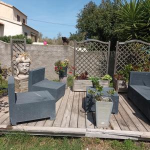 une terrasse en bois avec des chaises et des plantes en pot dans l'établissement Maison bord de mer, à Penta-di-Casinca