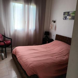 - une chambre avec un lit, une chaise et une fenêtre dans l'établissement Maison bord de mer, à Penta-di-Casinca