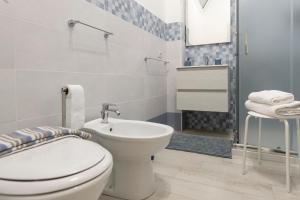 a white bathroom with a toilet and a sink at Pozzallo cozy house vista mare in Pozzallo +16 photos