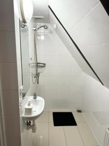 y baño blanco con lavabo y ducha. en Villa Vincentów, en Myślenice