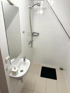 Baño blanco con lavabo y espejo en Villa Vincentów, en Myślenice