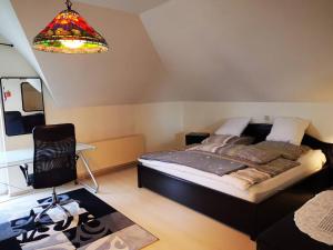 een slaapkamer met een bed, een stoel en een lamp bij 2 bedrooms apartement with enclosed garden and wifi at Limbach Kirkel in Altstadt
