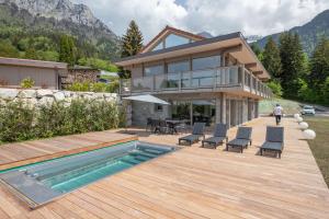 a house with a deck with a swimming pool at Lot appartements Adret et Ubac in Rovagny