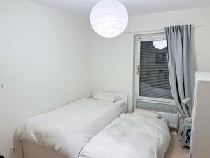 biała sypialnia z 2 łóżkami i oknem w obiekcie Room in Guest room - Guest room - 5 Min Walk Eurovision Hyllie w Malmö