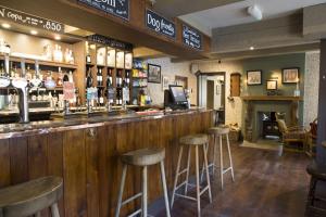 um bar com bancos num pub com lareira em The Wheatsheaf Inn em Kendal