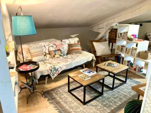 uma sala de estar com um sofá e duas mesas em 16 Bis-Gîte-Hôtel-Studio em Marssac-sur-Tarn