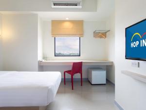um quarto com uma cama, uma secretária e uma televisão em Hop Inn Kanchanaburi Building B em Kanchanaburi