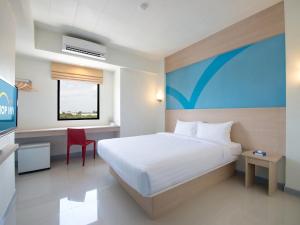 Habitación de hotel con cama y escritorio en Hop Inn Kanchanaburi Building B en Kanchanaburi