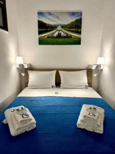 a bedroom with a bed with towels on it at B&B Smart Station Caserta in Caserta