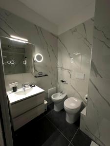 a bathroom with a sink and a toilet and a mirror at B&B Smart Station Caserta in Caserta