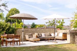 eine Terrasse mit Stühlen, Tischen und Sonnenschirmen in der Unterkunft Ferienwohnungen in der Villa Lindenallee 9 in Malente