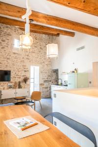 eine Küche und ein Esszimmer mit einem Holztisch und Stühlen in der Unterkunft La Maison Favier in Saint-Rémy-de-Provence