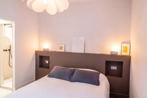 ein Schlafzimmer mit einem Bett mit einem braunen Kopfteil in der Unterkunft La Maison Favier in Saint-Rémy-de-Provence