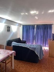 een woonkamer met paarse gordijnen en een bank bij COSTA DAURADA APARTAMENTS - Pompeyo in Cambrils