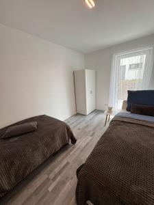 a white bedroom with two beds and a window at Apartment Weikersheim V in Weikersheim