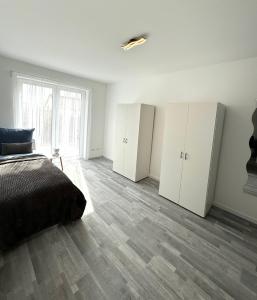 ein Schlafzimmer mit weißen Schränken und einem Bett darin in der Unterkunft Apartment Weikersheim V in Weikersheim