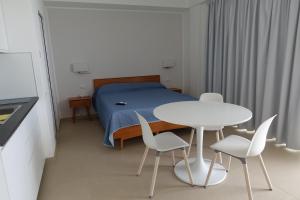 Schlafzimmer mit einem Bett, einem Tisch und Stühlen in der Unterkunft Hotel e Residence Il Faro Acciaroli in Acciaroli