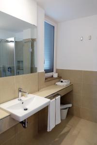 een badkamer met een wastafel en een spiegel bij Hotel e Residence Il Faro Acciaroli in Acciaroli