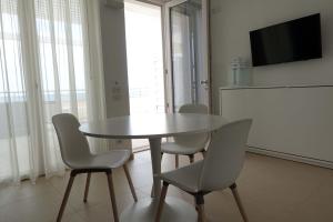 een eetkamer met een tafel en stoelen en een televisie bij Hotel e Residence Il Faro Acciaroli in Acciaroli
