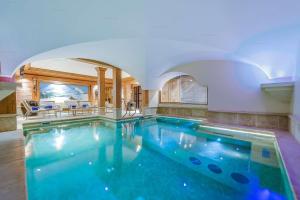 - une grande piscine dans une maison avec une arche dans l'établissement Val d’Isère - Extraordinaire Chalet Montana avec piscine sur la piste Olympique de Belevarde., à Val dʼIsère