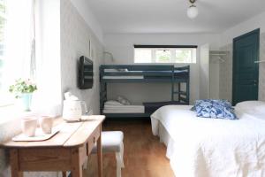 a bedroom with two beds and a desk and a bunk bed at Agda Lund Bed & Breakfast in Kivik