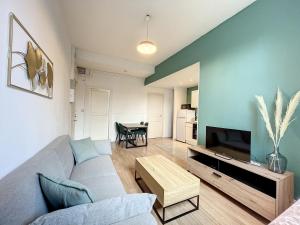 a living room with a couch and a tv at Le Green Lodge in Nevers