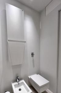 ein weißes Bad mit einem WC und einem Waschbecken in der Unterkunft Duomo intero appartamento in Mailand