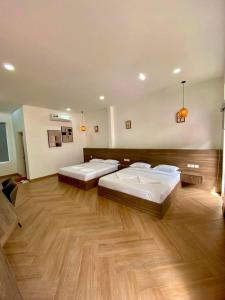 2 camas num quarto amplo com pisos em madeira em BOPHAMANSION em Phumĭ Ŏng Char