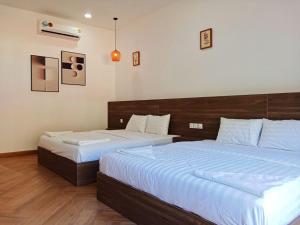 a bedroom with two beds with white sheets at BOPHAMANSION in Phumĭ Ŏng Char
