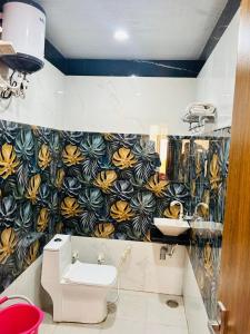 a bathroom with a toilet and a flower patterned wall at Yoga Homestay in Agra