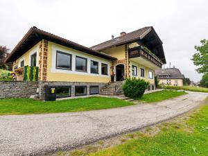 une grande maison jaune avec une allée. dans l'établissement Spacious Apartment in Katschberg, à Sankt Michael im Lungau