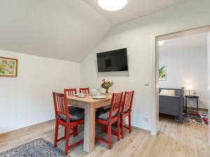 a dining room with a table and chairs and a television at Spacious Apartment in Katschberg in Sankt Michael im Lungau