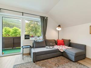 a living room with a couch and a large window at Spacious Apartment in Katschberg in Sankt Michael im Lungau