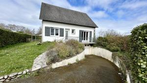 ein weißes Haus mit einem schwarzen Dach in der Unterkunft Maison avec jardin: La cabane aux oiseaux in Saint-Valery-sur-Somme