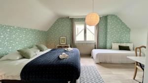 ein Schlafzimmer mit zwei Betten mit grün-weißer Tapete in der Unterkunft Maison avec jardin: La cabane aux oiseaux in Saint-Valery-sur-Somme