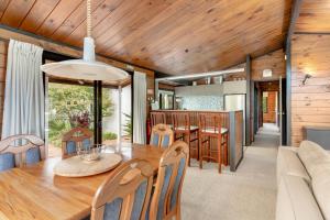 a dining room and kitchen with a table and chairs at Pauanui Beach House Suntrap in Pauanui