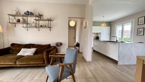 a living room with a couch and a kitchen at Maison avec jardin: La cabane aux oiseaux in Saint-Valéry-sur-Somme