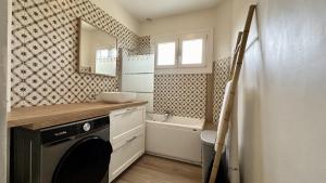 ein Badezimmer mit einer Waschmaschine und einem Spiegel in der Unterkunft Maison avec jardin: La cabane aux oiseaux in Saint-Valery-sur-Somme + 15 Fotos