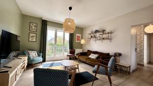 ein Wohnzimmer mit einem Sofa und einem Tisch in der Unterkunft Maison avec jardin: La cabane aux oiseaux in Saint-Valery-sur-Somme