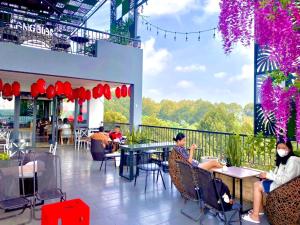 um grupo de pessoas sentadas em mesas em um restaurante em Hotel Stylish Binh Long em Thanh Bình
