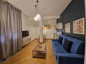 a living room with a blue couch and a table at U Genova in Genoa