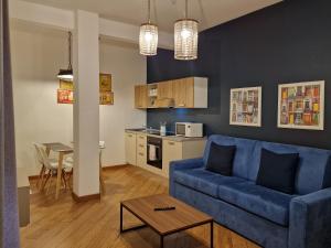 a living room with a blue couch and a kitchen at U Genova in Genova