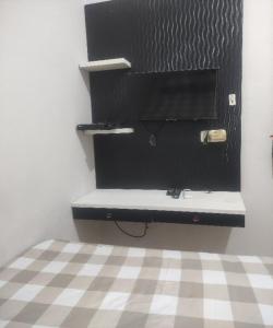 a bedroom with a black desk and a checkered floor at SPOT ON 93853 Budi Residence 2 in Bekasi