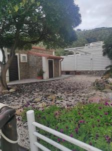 einen weißen Zaun vor einem Haus mit Blumen in der Unterkunft Hotel e Residence Il Faro Acciaroli in Acciaroli