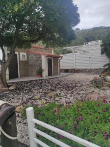 a white fence in front of a house with flowers at Hotel e Residence Il Faro Acciaroli in Acciaroli